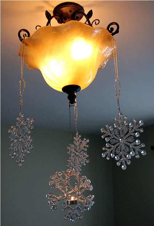 hanging snowflake ornaments from light fixture